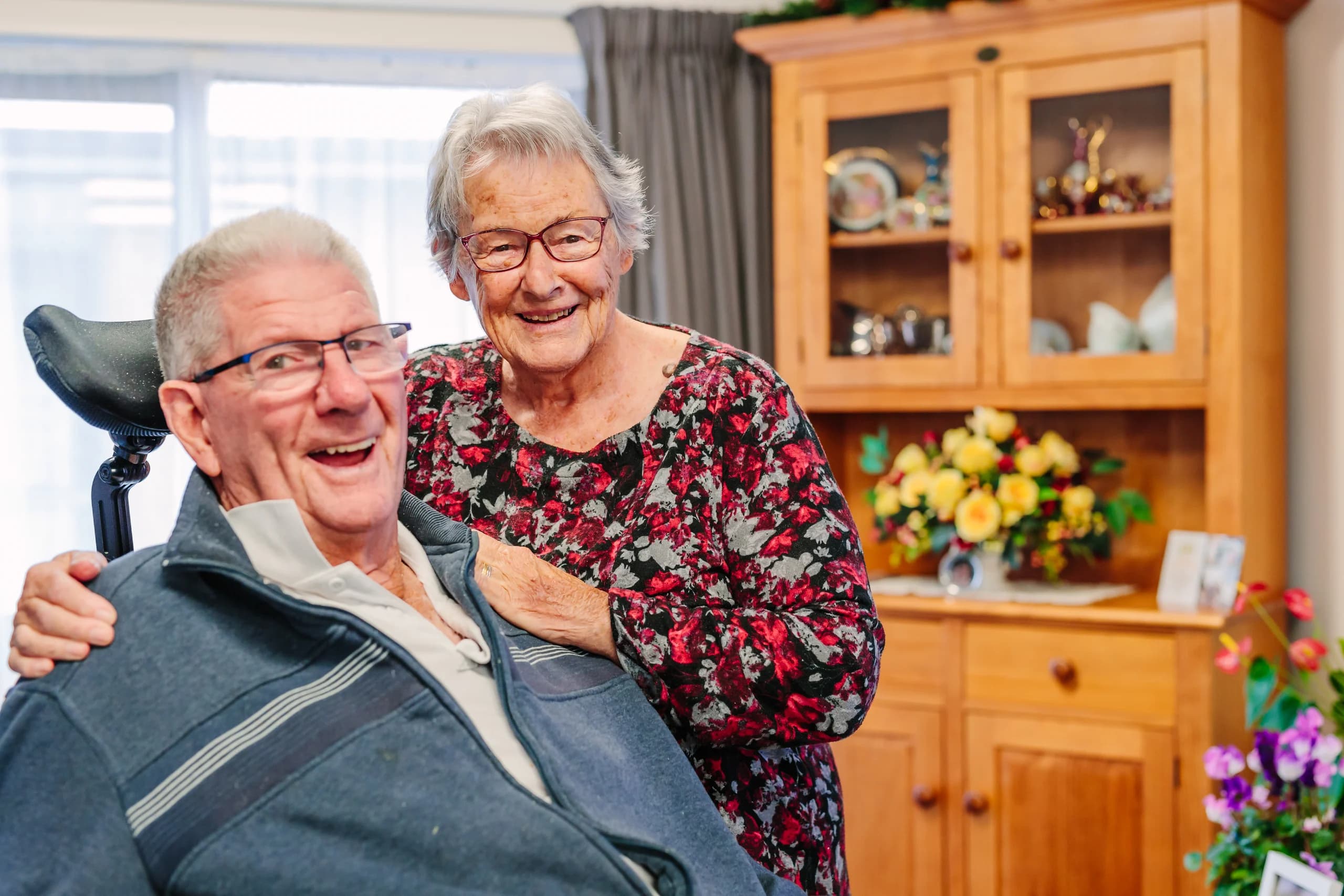 A couple smiling together in a living space