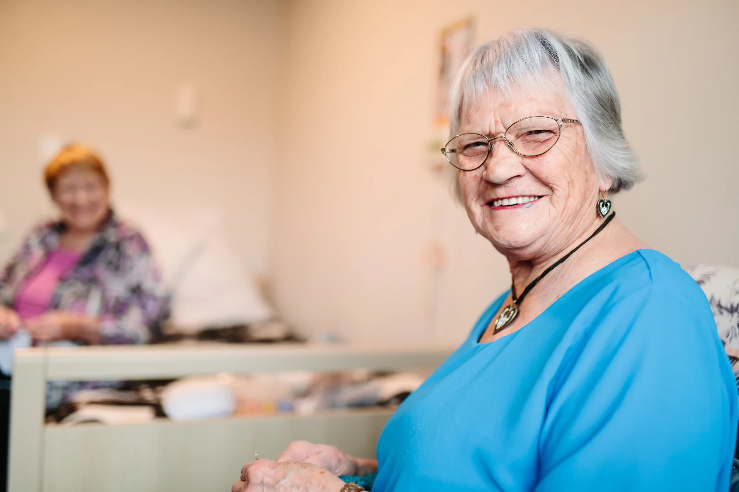 A resident smiling in a shared lounge