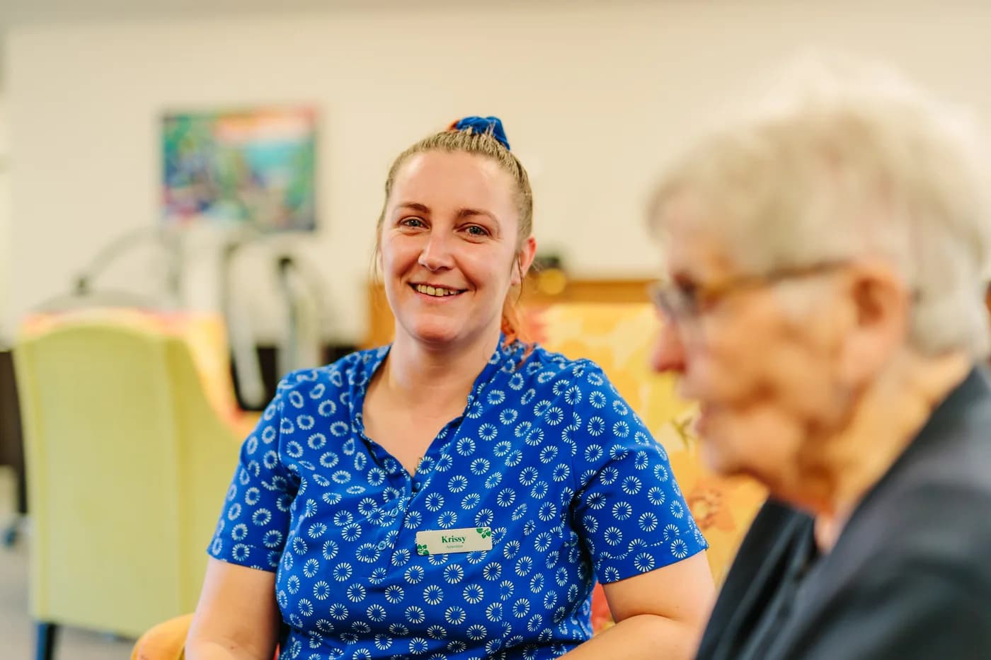 A Promisia team member talking with a resident
