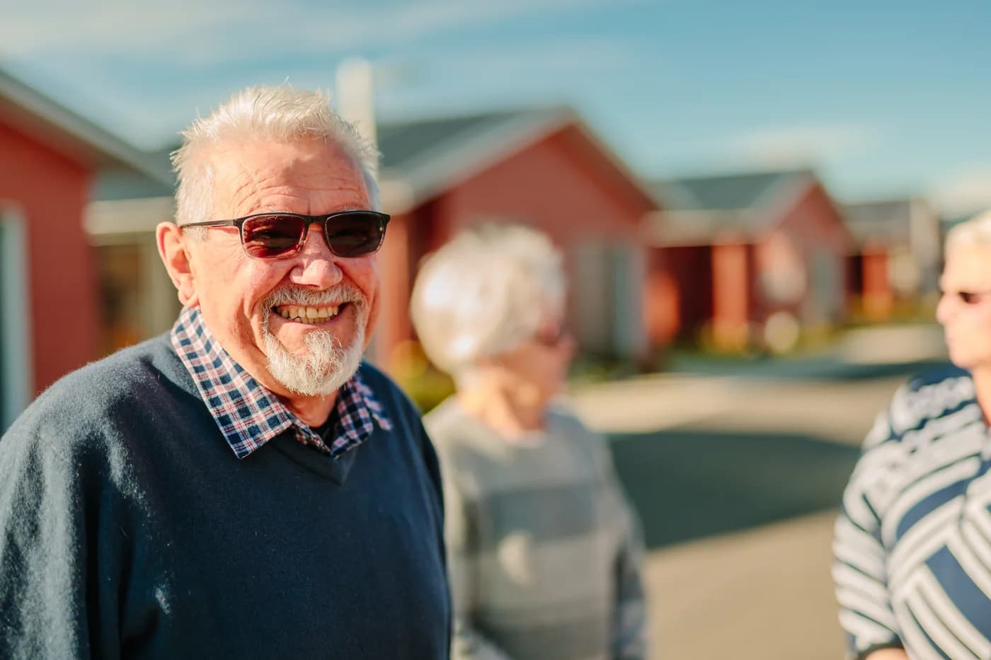 A resident smiling outdoors at a Promisia village