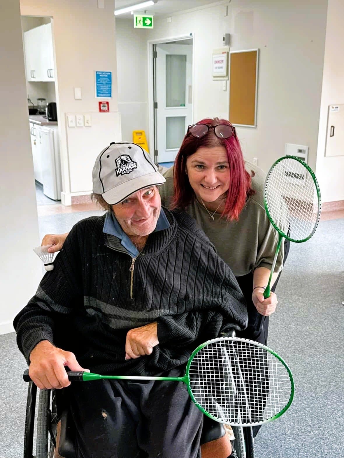 Debbie and a resident holding badminton racquets at Aldwins House